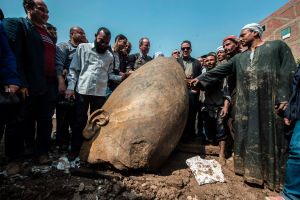 TOPSHOT - Egyptian minister of antiquates Khaled el-Anani poses for picture with workers next to the head of a statue at the site of a new discovery by a team of German-Egyptian archeologists in Cairo's Mattarya district on March 9, 2017. Statues of the kings and queens of the nineteenth dynasty (1295 - 1185 BC) were unearthed in the vicinity of the Temple of Ramses II in what was the old Pharonic city.