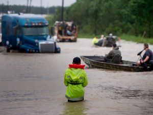 People make their way through a flooded street in the aftermath of Hurricane Harvey on August 29, 2017 in Houston, Texas.