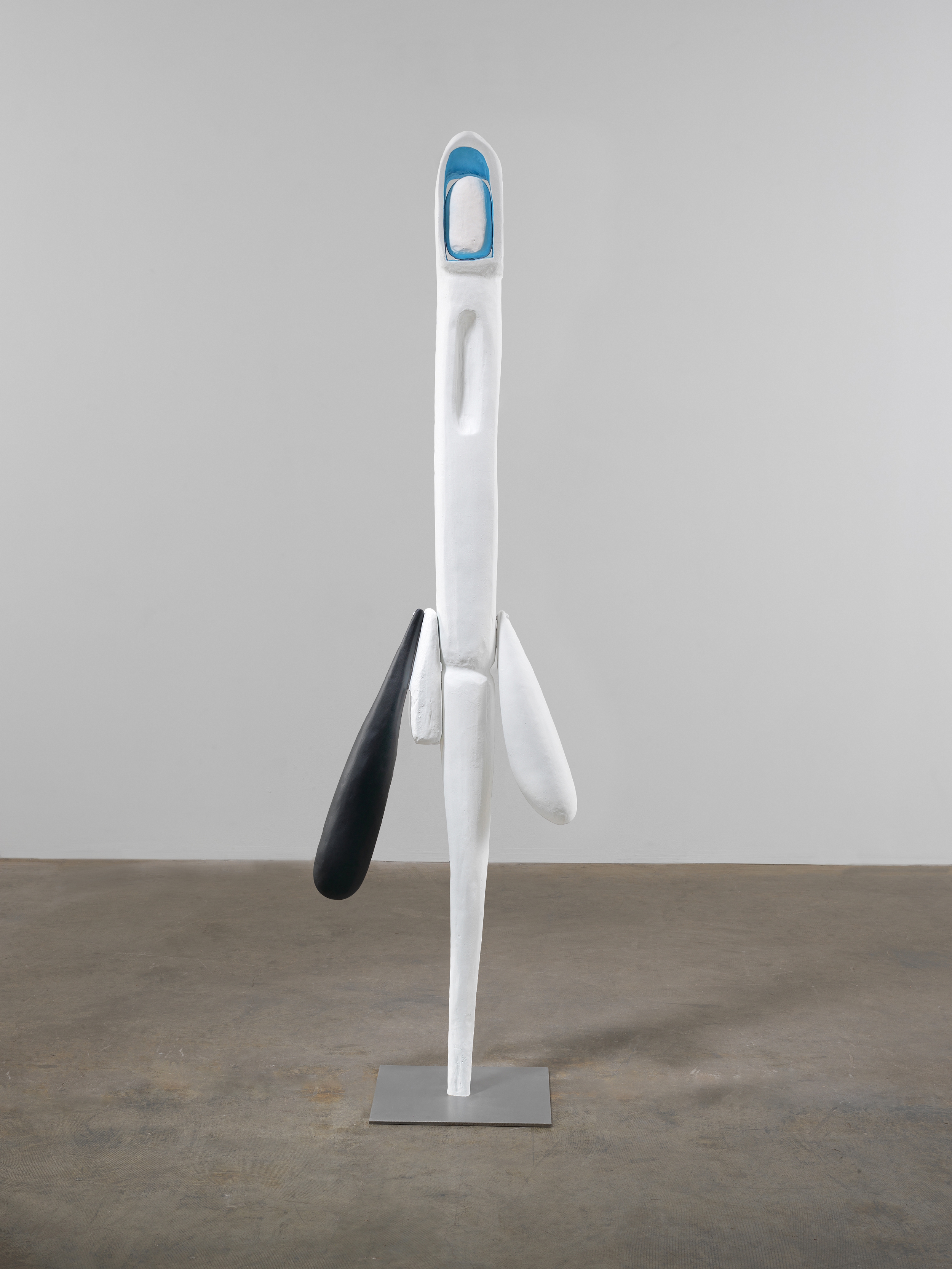 Large white pole sculpture with various appendages attached