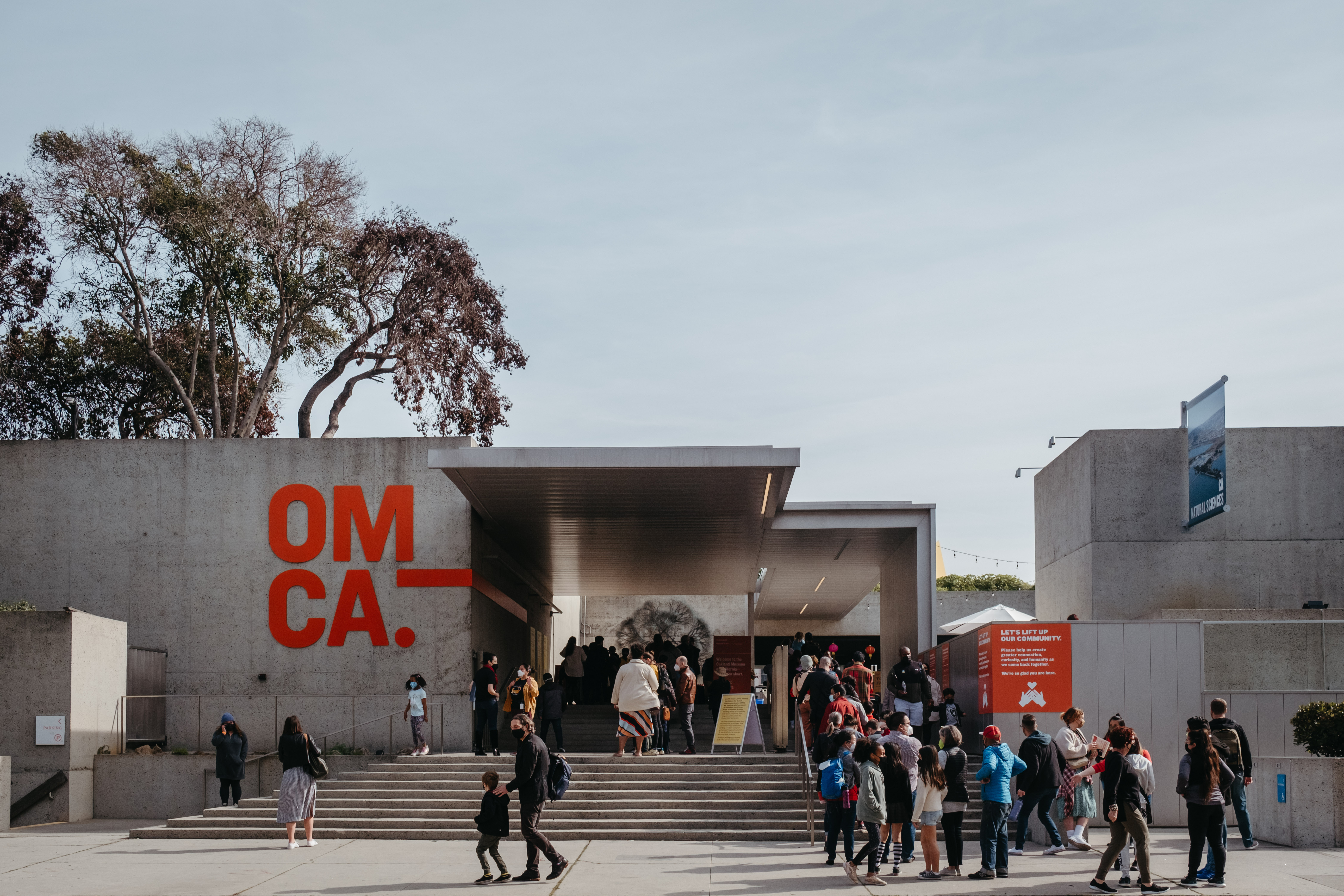 A photograph of people lined up in front of a museum