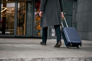 man walking with a rolling suitcase