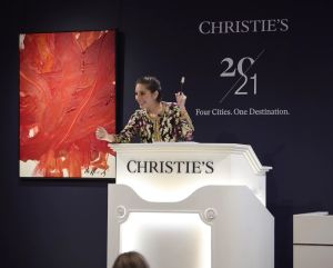 Image of a woman auctioneer on the rostrum.