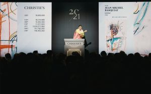 Image of a woman with a gavel on a rostrum during an auction