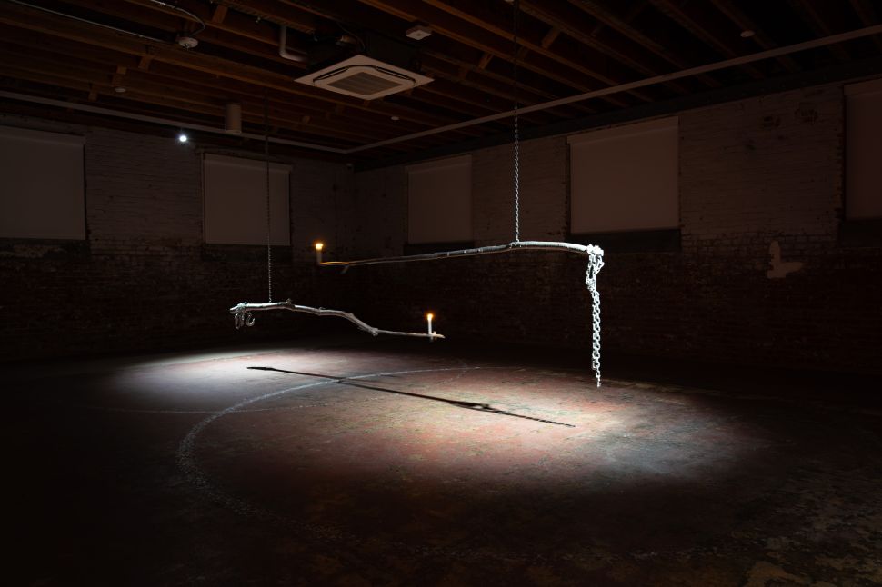 Dark room with a mechanic arm holding candles. 
