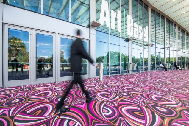 Image of a man walkimng on a pink carpet.