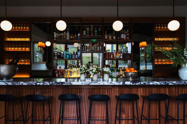 The bar area, with seating and stocked shelves, at Coucou