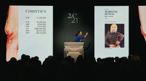 Auctioneer Yü-Ge Wang takes a bid at Christie’s 21st Century Evening Sale with Marlene Dumas’s painting Miss January displayed on screen as the top lot.
